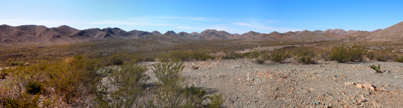 [More dirt and small rocks than sagebrush in this image. The highway is barely visible below the peaked hills in the distance.]